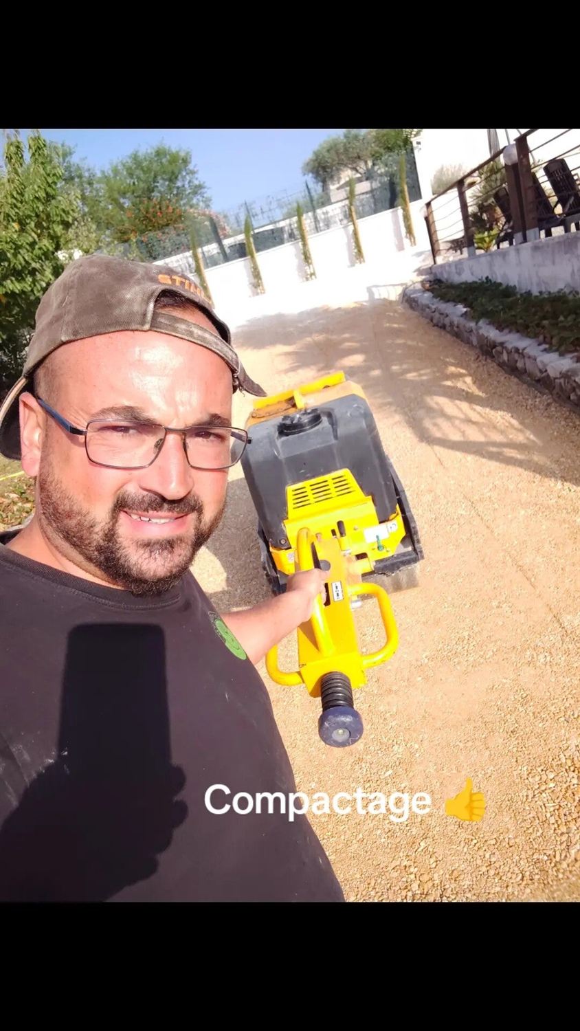 Jason Roustan sur un chantier, plaque vibrante à la main