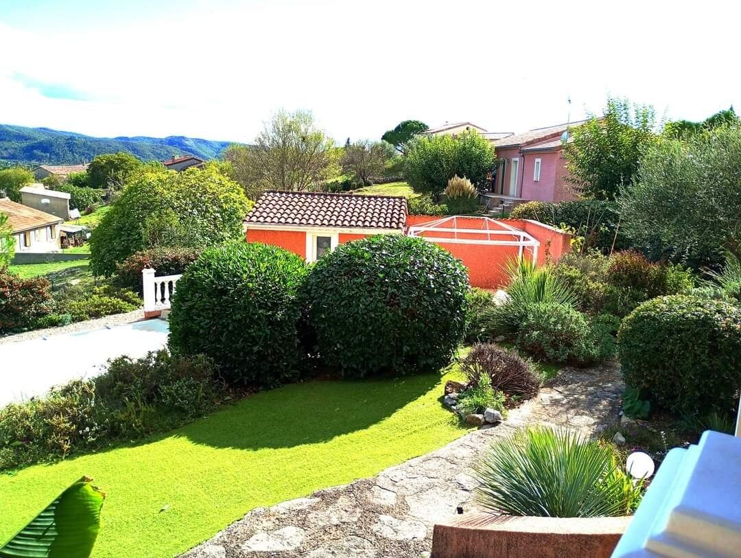 Jardin entretenu vu de haut : pelouse tondue et arbustes taillés en boule