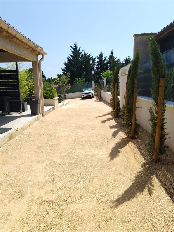 Allée gravillonnée bordée de cyprès