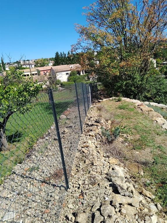 Grillage rigide posé au-dessus d'un enrochement