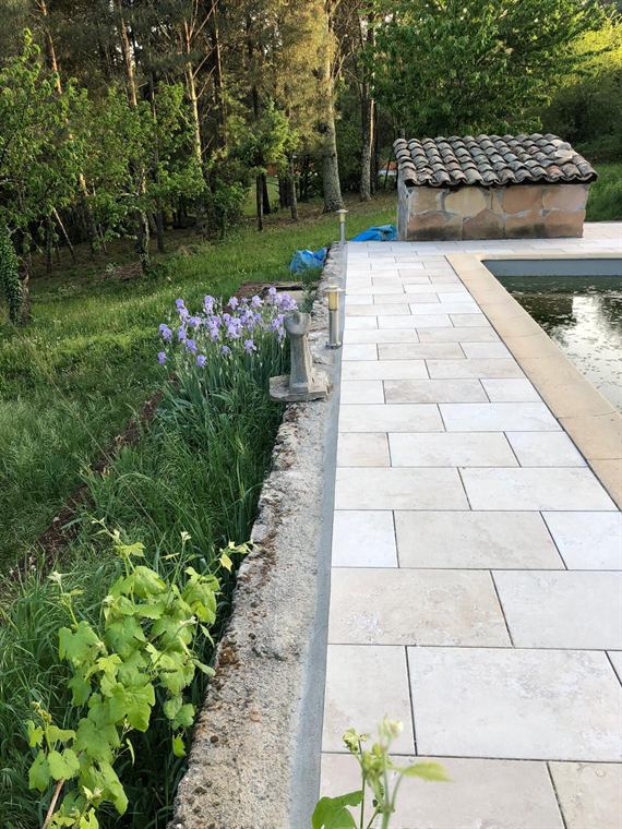 Dallage de terrasse et massifs de lavande au bord d'une piscine